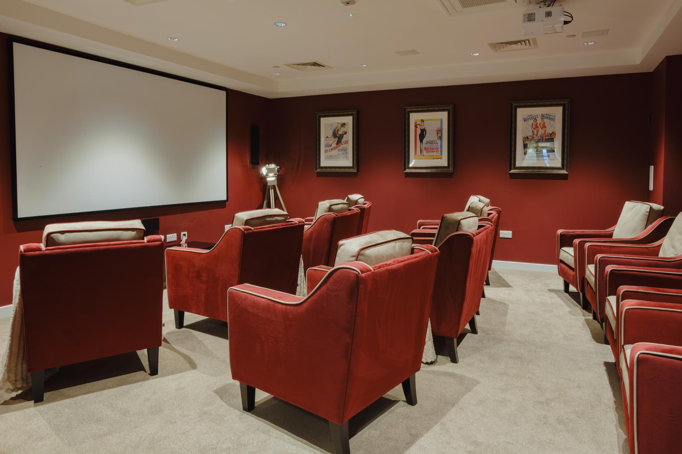 care home cinema with red walls and large chairs