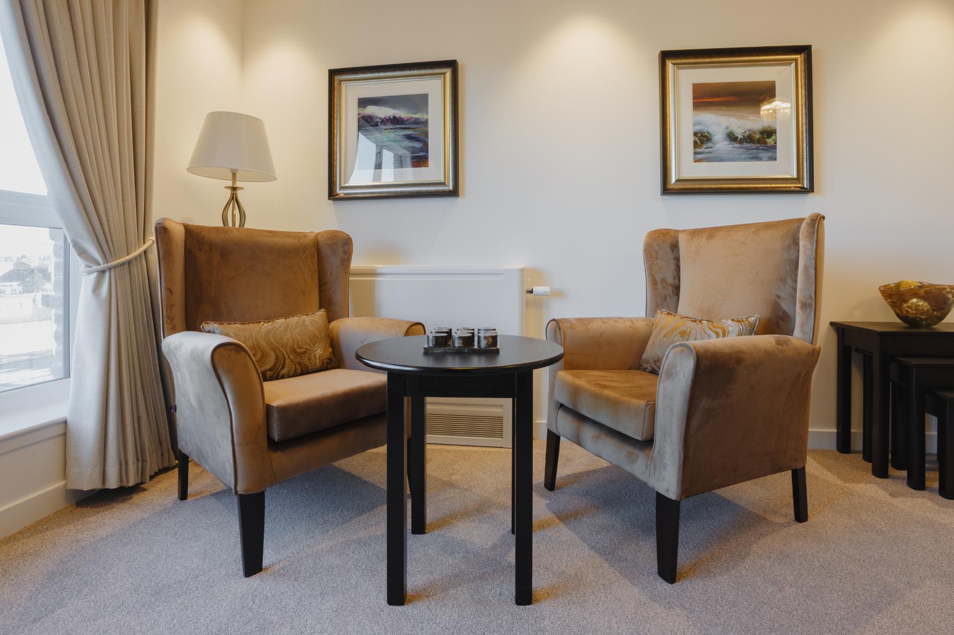 two chairs with table between