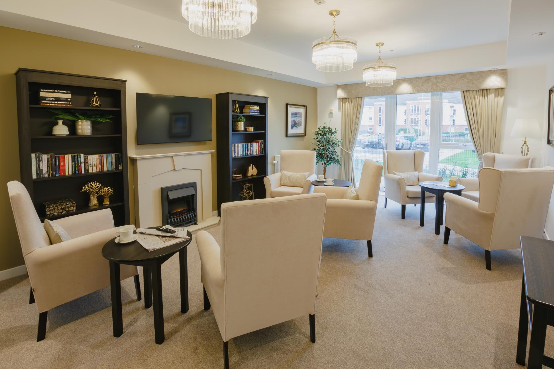 care home lounge with cream chairs and black bookshelves