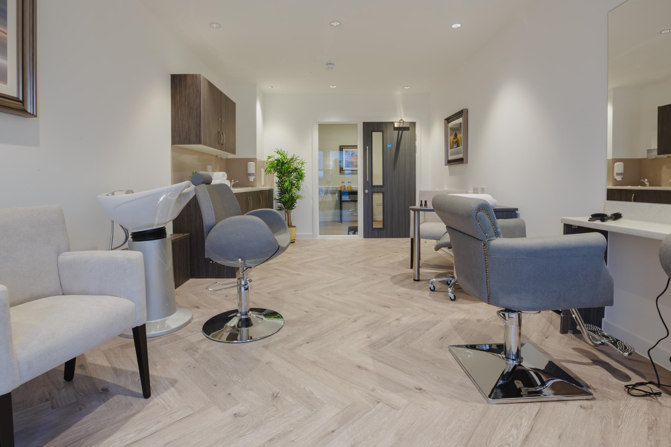 hair salon in care home with grey chairs, basins and mirrors