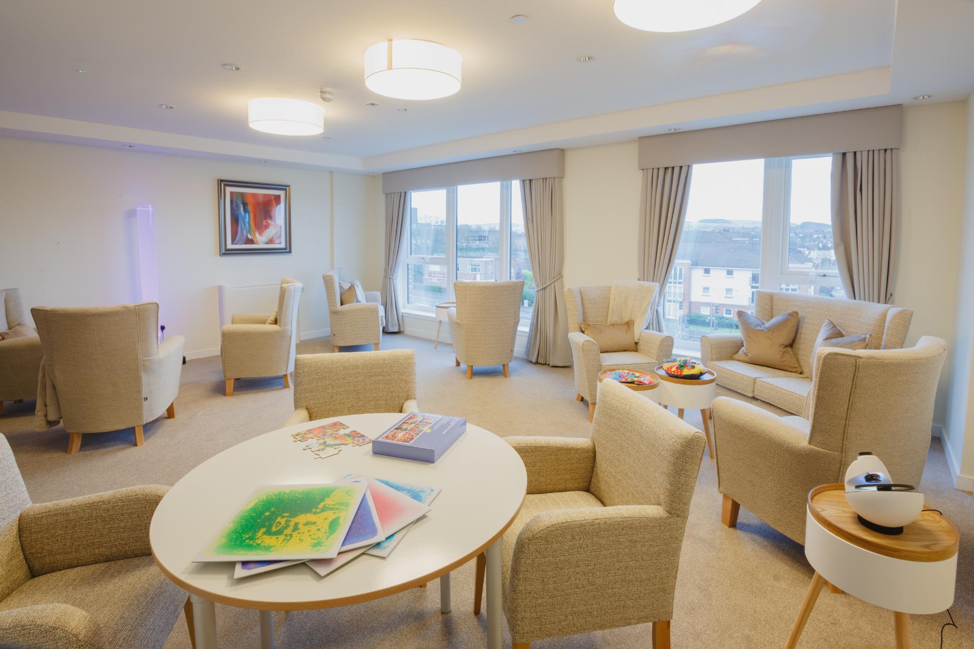 sensory room with cream chairs, tables and calming lights