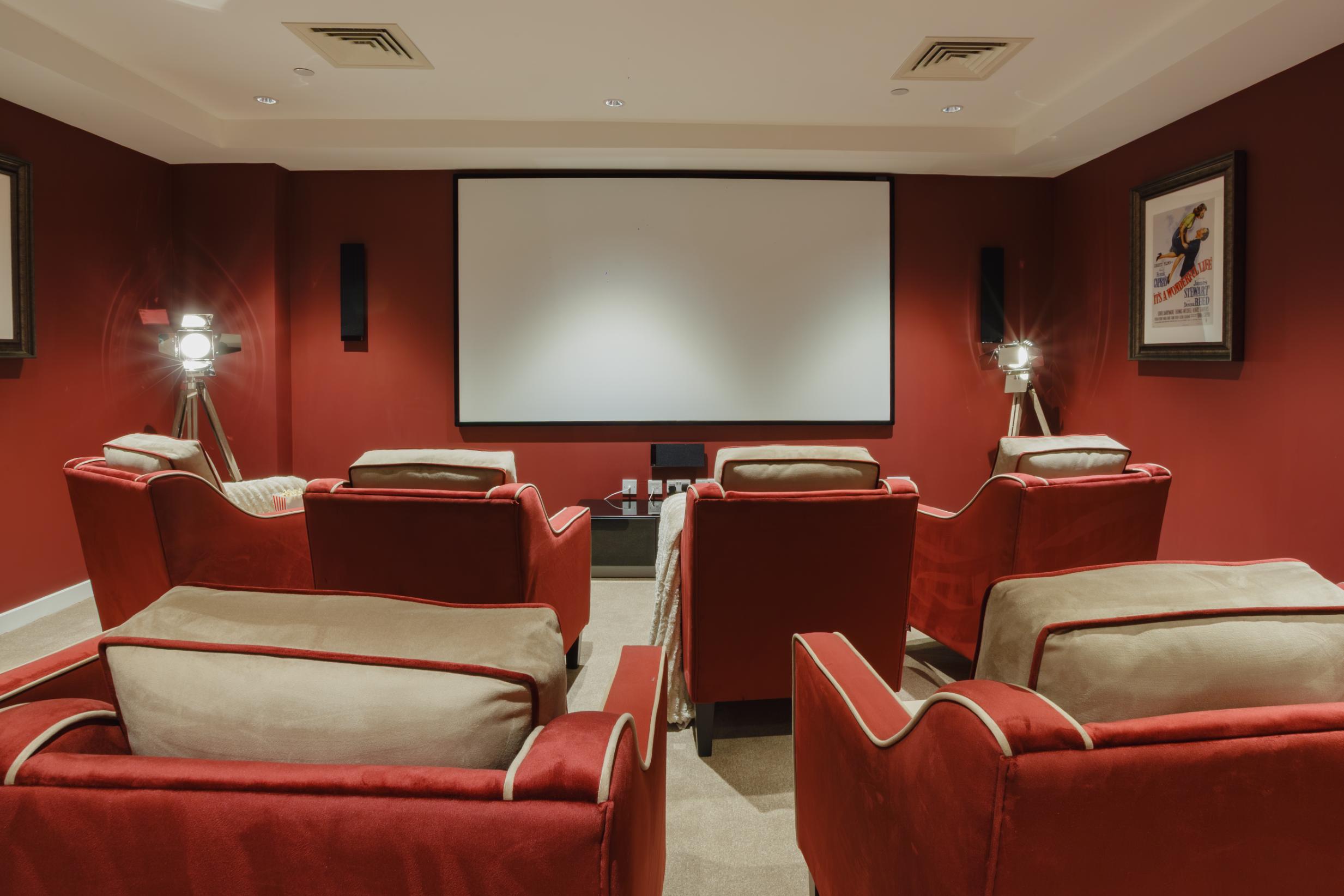cinema room with red walls and armchairs