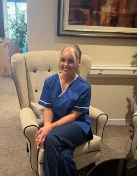 nurse in blue uniform sat in armchair