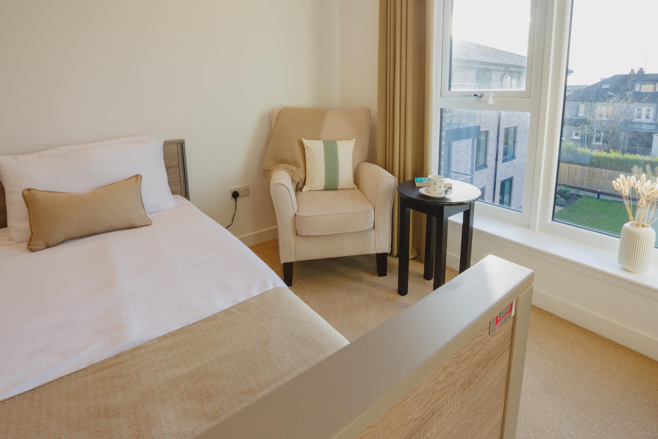 care home profiling bed with armchair and large window